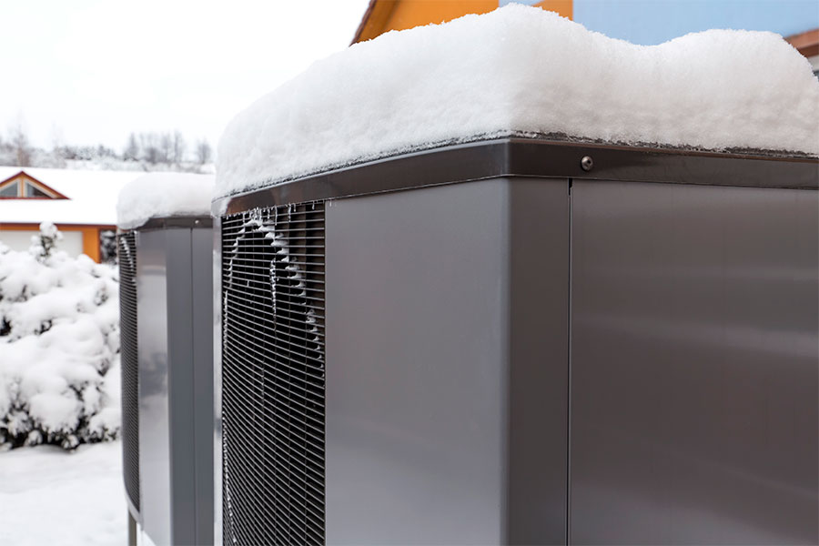 Mountain Heating and Cooling winter heat pump covered in snow.