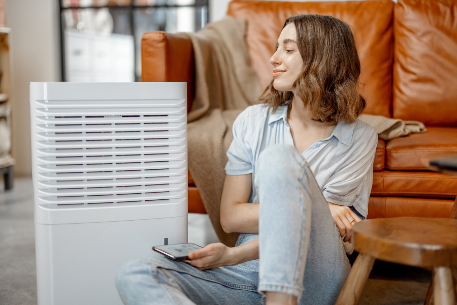 Woman sitting by portable air filter