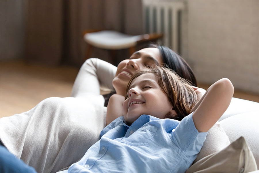 Mother and daughter enjoying summer air conditioning cool living room