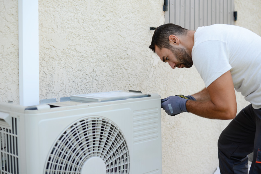 HVAC technician installing home air conditioner unit