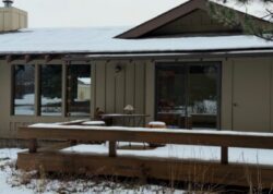 View of the front of the home with the snow-covered deck