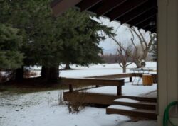 Looking out from the home over snowy deck and field